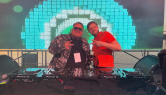 Dwóch DJ-ów – DJ Zabor i DJ Revixer - pozuje za konsoletą DJ-ską na tle ekranu LED.