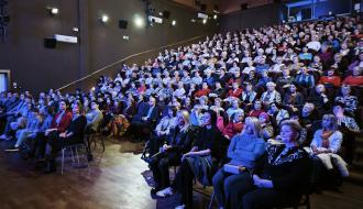 Szczelnie wypełniona widownia w sali widowiskowej RCK. Na przedzie panie siedzą na dostawionych krzesłach