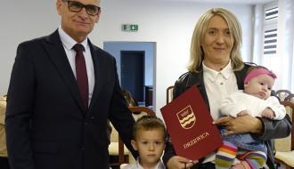 Burmistrz Drzewicy Janusz Reszelewski z mamą trzymającą małe dziecko. W środku starszy brat niedawno urodzonej dziewczynki