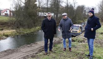 Na trawie nad terenem budowy stoją od lewej Burmistrz Drzewicy Janusz Reszelewski, Kierownik Ref. Inwestycji UM Jarosław Bomba i Zastępca Burmistrza Dominik Niemirski.