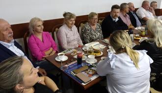 Przy stole siedzą uczestniczący w sesji sołtysi