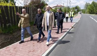 Uczestnicy odbioru idą chodnikiem na ulicy Żeromskiego w Drzewicy. Na czele trzyosobowa delegacja samorządu Gminy Drzewica – od lewej: Kierownik Referatu Gospodarki Komunalnej, Budownictwa i Inwestycji Urzędu Miejskiego w Drzewicy Jarosław Bomba, Burmistrz Drzewicy Janusz Reszelewski, Zastępca Burmistrza Dominik Niemirski.