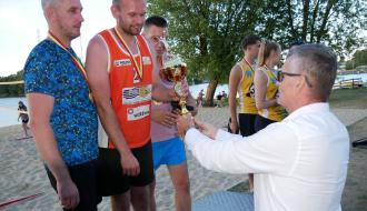 Burmistrz Drzewicy Janusz Reszelewski wręcza puchar stojącym na podium trzem zawodnikom z drużyny, która zajęła drugie miejsce.