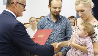Burmistrz Drzewica Janusz Reszelewski wręcza list gratulacyjny rodzicom jednego z dzieci