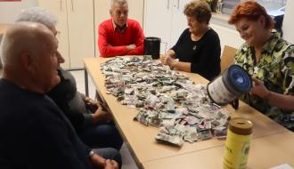 Pięcioro społeczników TPD – trzy panie i dwóch panów – siedzi przy stole, na którym wysypano pieniądze z puszek kwestarskich. Społecznicy znajdują się w sali stowarzyszeń RCK w Drzewicy