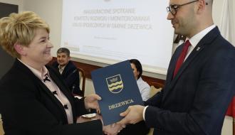 Dyrektor MGOPS w Drzewicy Marta Woźniak odbiera akt powołania do Komitetu z rąk Zastępcy Burmistrza Drzewicy Dominika Niemirskiego.