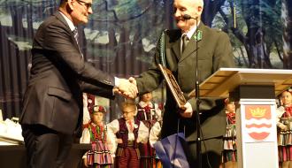 Na scenie Burmistrz Drzewicy Janusz Reszelewski przekazuje pamiątkowy dyplom i gratulacje Prezesowi Koła Łowieckiego „Gerlach” Andrzejowi Sołtysiakowi.