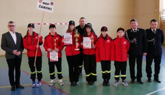 Młodzieżowa Drużyna Pożarnicza dziewcząt z OSP Żardki wraz z opiekunami stoi w jednym rzędzie z Burmistrzem Drzewicy i Gminnym Komendantem ZOSP RP w Drzewicy