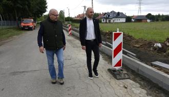 Wiceburmistrz Drzewicy i Kierownik Referatu Inwestycji UM w Drzewicy idący drogą wzdłuż terenu budowy powiatowej Drzewica – Dąbrówka i inspekcjonujący przebieg prac budowlanych.