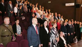 Uczestnicy inauguracji roku akademickiego w sali widowiskowej RCK stoją podczas oficjalnej części uroczystości.