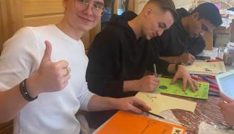 Trzech uczestników projektu podczas zajęć edukacyjnych