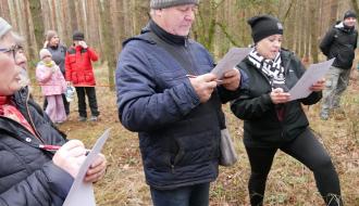 W lesie na szczycie Żurawiej Góry troje uczestników – dwie panie i mężczyzna – rozwiązuje test pisemny o Drzewicy