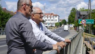 Wicewojewoda Łódzki i Burmistrz Drzewicy opierają się o barierki mostu i przyglądają się budowie nad rzeką.