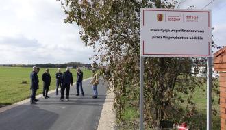 Przy wyremontowanej drodze gminnej w Trzebinie tablica informująca o dofinansowaniu inwestycji ze środków Województwa Łódzkiego
