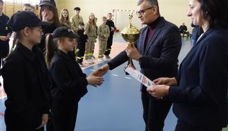 Burmistrz Drzewicy Janusz Reszelewski wręcza puchar za pierwsze miejsce druhnom ze zwycięskiej drużyny MDP Domaszno