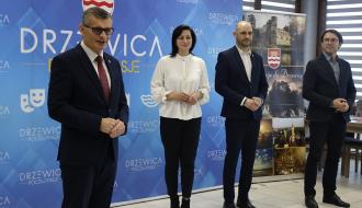Głos zabiera Burmistrz Drzewicy Janusz Reszelewski. Obok po prawej stoją: Przewodnicząca Rady Miejskiej w Drzewicy Dorota Wiktorowicz, Zastępca Burmistrza Dominik Niemirski i Sekretarz Miasta Andrzej Krzyżanowski