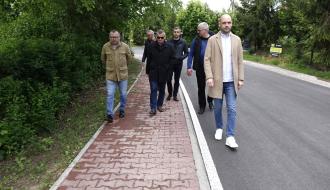 Sześciu uczestników odbioru idzie przebudowaną drogą i ciągiem pieszym na ulicy Słowackiego w Drzewicy