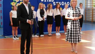 Uroczysta inauguracja roku szkolnego w SP w Radzicach. Przemawia Zastępca Burmistrza Drzewicy Dominik Niemirski. Obok Dyrektor SP w Radzicach Małgorzata Wawrzyńczak-Pawul