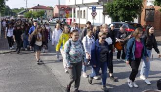 Grupa pielgrzymów maszeruje ulicą Kilińskiego w Drzewicy