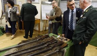 Uczestnicy obchodów oglądają wystawę z okazji 75-lecia Koła Łowieckiego „Gerlach”. Pierwsi po prawej przy strzelbach myśliwskich stoją Członek Naczelnej Rady Łowieckiej Waldemar Komenda i Burmistrz Drzewicy Janusz Reszelewski.