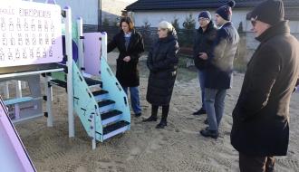 Pięć osób biorących udział w odbiorze inwestycji stoi przy urządzeniu wielofunkcyjnym