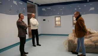 Pomalowane w odcieniach koloru niebieskiego pomieszczenie bawialni oglądają od lewej: Burmistrz Drzewicy Janusz Reszelewski, Zastępca Burmistrza Dominik Niemirski oraz Kierownik Referatu Gospodarki Komunalnej, Budownictwa i Inwestycji Urzędu Miejskiego w Drzewicy. 