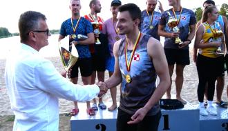 Burmistrz Drzewicy Janusz Reszelewski wręcza puchar dla najlepszego zawodnika turnieju. W tle drużyny stojące na podium