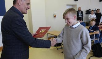 Burmistrz Drzewicy Janusz Reszelewski gratuluje Bartłomiejowi Kupisowi trzeciego miejsca w starszej grupie wiekowej