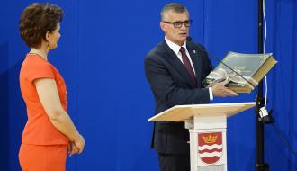 Burmistrz Drzewicy Janusz Reszelewski prezentuje kronikę szkoły – prezent od gminnego samorządu. Po lewej Dyrektor SP w Brzustowcu Barbara Stolarczyk.