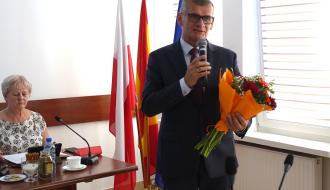 Trzymając kwiaty i mikrofon przemawia Burmistrz Drzewicy Janusz Reszelewski.