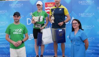 Na podium najlepszy biegach i najlepsza biegaczka z Gminy Drzewica – Michał Franczak i Dominika Domańska. . Po lewej przy podium stoi Zastępca Burmistrza Drzewicy Dominik Niemirski, po prawej Dyrektor Banki Spółdzielczego w Przysusze – Oddziału w Drzewicy Ewa Jakubczyk.