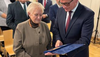 Burmistrz Drzewicy Janusz Reszelewski przekazuje Pani Profesor Akt Nadania Honorowego Obywatelstwa Gminy i Miasta Drzewica.