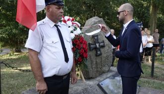 Przy obelisku i wieńcu Zastępca Burmistrza Drzewicy Dominik Niemirski. Po lewej strażak OSP