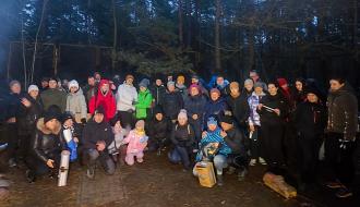 Wspólne nocne zdjęcie kilkudziesięcioosobowej grupy piechurów w lesie na terenie Domku Myśliwskiego