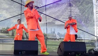 Na scenie koncert grupy „Boys” - trzej wykonawcy w pomarańczowych uniformach