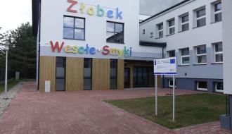 Nowoczesny budynek żłobka „Wesołe Smyki” z przestronnym wejściem i estetycznie zagospodarowanym terenem wokół.