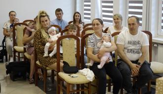Widok ogólny na salę USC. Rodzice z bobasami siedzą na krzesłach.