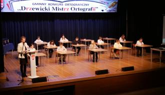 Dyktando na scenie sali widowiskowej RCK piszą uczniowie klas IV-V