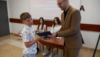 Podziękowania z rąk Zastępcy Burmistrza Drzewicy, za realizację grantu odbiera uczeń SP w Idzikowicach.