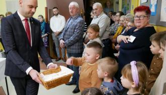 Uczestnicy spotkania łamią się opłatkiem
