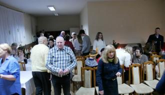 Uczestnicy spotkania łamią się opłatkiem