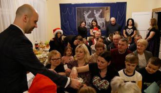 Uczestnicy spotkania łamią się opłatkiem