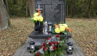 Pomnik nagrobny ofiar tragedii drogowej pod Nowym Miastem. Na płycie nagrobnej wygrawerowane nazwiska ofiar. Poniżej znicze i wieńce.