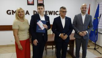 Z rąk Burmistrza Drzewicy Janusza Reszelewskiego stypendium odbiera Sergiusz Stuleblak. Obok (po lewej) Dyrektor ZEAS w Drzewicy Agnieszka Kwiecień i (po prawej) Zastępca Burmistrza Drzewicy Dominik Niemirski.