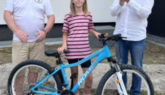 W środku dziewczynka z wylosowanym rowerem. Po lewej Prezes Koła nr 3 PZW w Drzewicy Ziemowit Jaciubek, po prawej bijący brawo Burmistrz Drzewicy Janusz Reszelewski.
