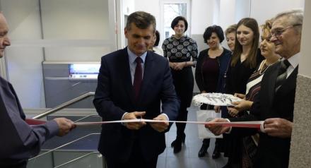 mężczyzna przecina wstęgę podczas ceremonii otwarcia Domu Dziennego „Senior+”