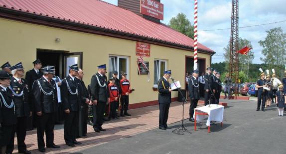 przemowa dowódcy w towarzystwie członków Ochotniczej Straży Pożarnej stojących przed jednostką OSP podczas ceremonii