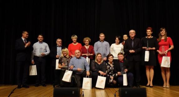 grupa osób uhonorowanych na sali widowiskowej Regionalnego Centrum Kultury w Drzewicy wraz z upominkami