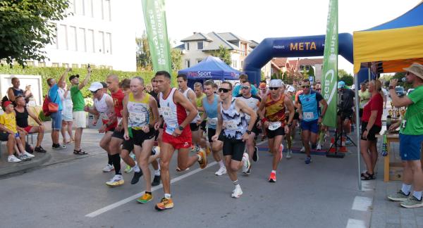 Na ulicy Staszica obok budynku Urzędu Miejskiego w Drzewicy grupa biegaczy rozpoczyna bieg główny na 5 km