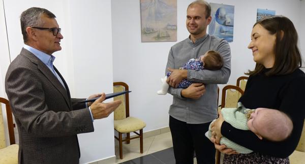 Burmistrz Drzewicy Janusz Reszelewski gratuluje rodzicom bliźniąt – Annie i Mariuszowi Skrętowskim, którzy trzymają bobasy na rękach.